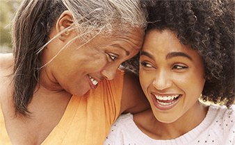 Two women smiling and laughing together.